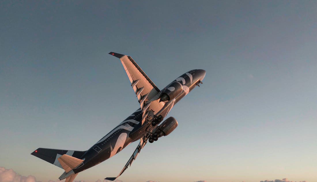 Avión de largo radio ascendiendo sobre el mar de nubes al amanecer